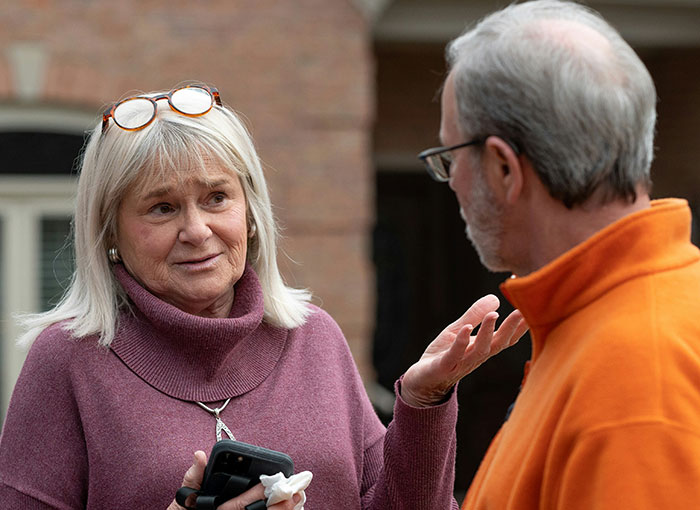 A woman with glasses on her head and a man with glasses talking, demonstrating unwritten rules of Brits.