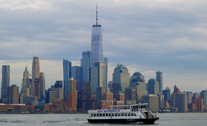 The New York City skyline with a ferry boat, illustrating US states glorified in movies.