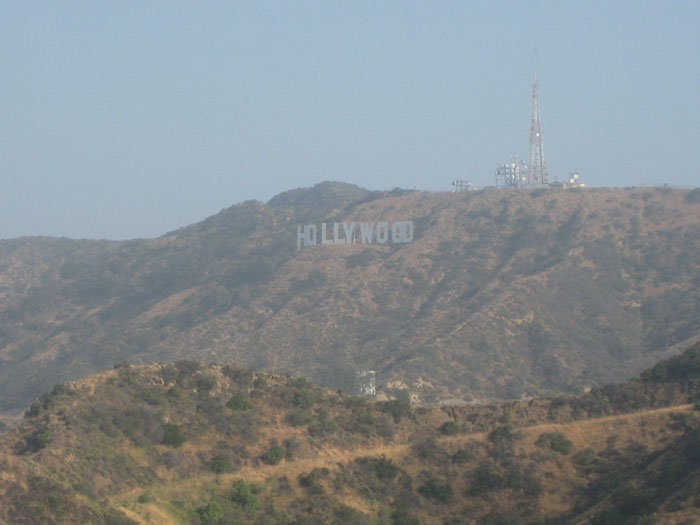 The iconic Hollywood sign on a hill, representing US states glorified in movies.
