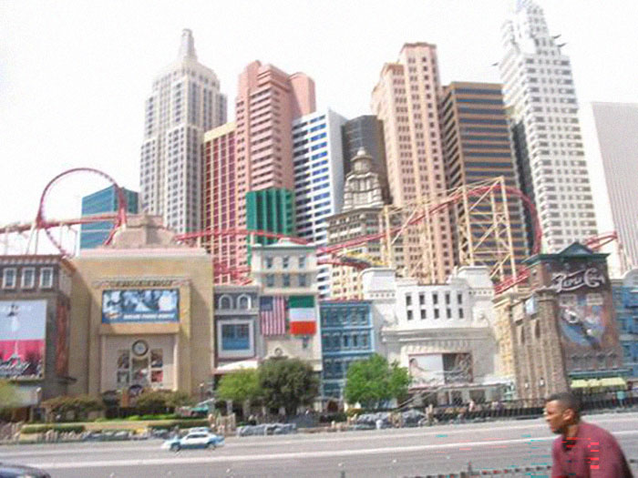 A bustling cityscape with tall buildings and roller coaster tracks, reflecting a vibrant part of the US States.