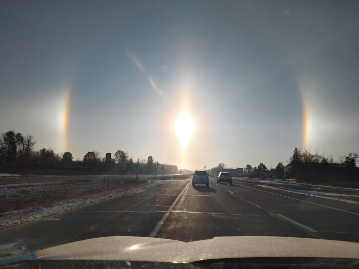 Rare atmospheric phenomenon with sun halo and bright arcs over highway
