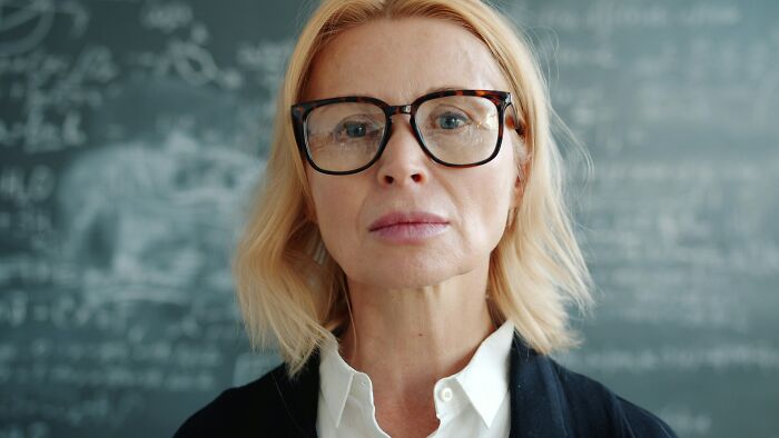Serious woman wearing glasses representing choosing peace over paycheck