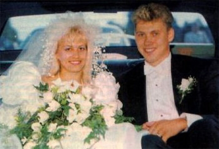 Vintage creepy photo of a happy couple dressed for a formal event with a large bouquet