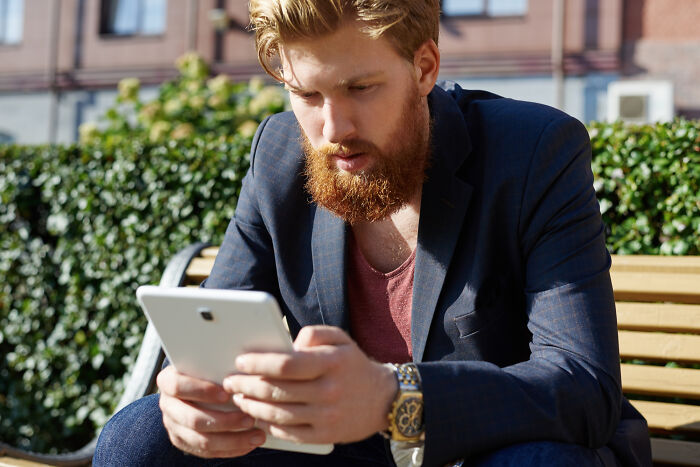 Man with beard using tablet outdoors at wild weddings