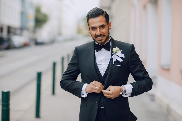 Groom smiling confidently in tuxedo at wild weddings