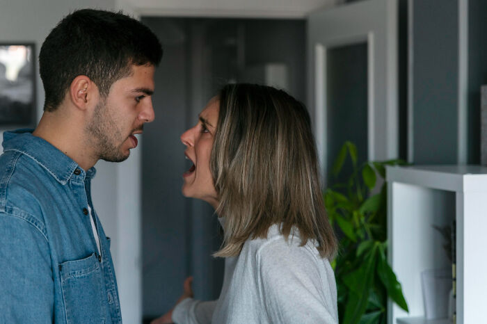 Couple arguing intensely inside a home setting