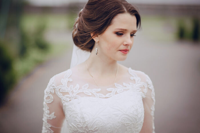 Bride in white wedding dress with intricate lace details outdoors