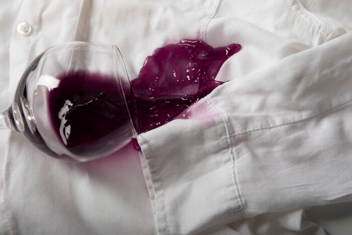 Spilled red wine on white shirt at wedding