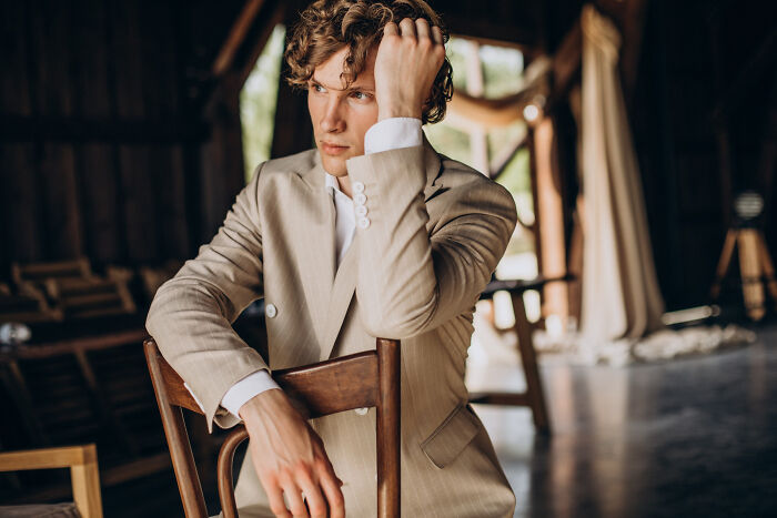 Man in light suit sitting on chair at wild weddings