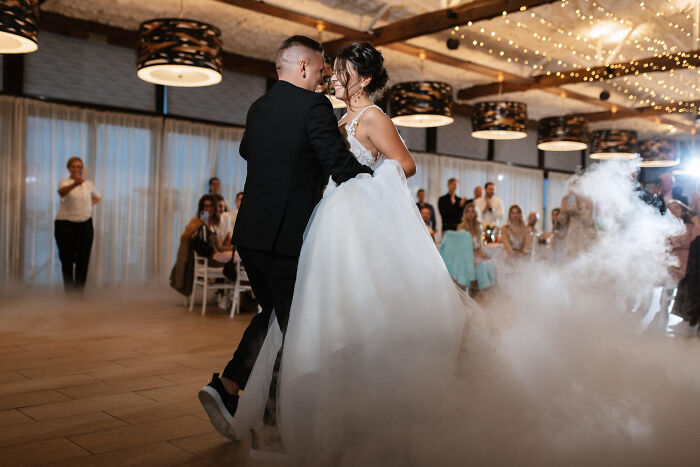 Bride and groom dancing surrounded by guests and wedding decor