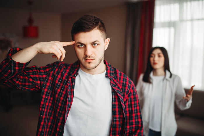 Man making frustrated gesture during couple's heated argument