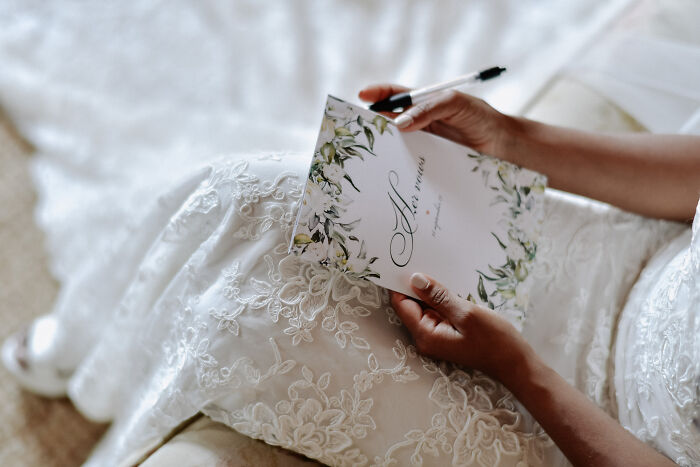 Bride writing vows in floral notebook at wild weddings