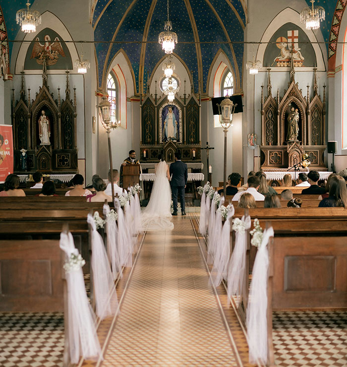 A couple at a wedding ceremony in a decorated church, highlighting a beautiful marriage moment.