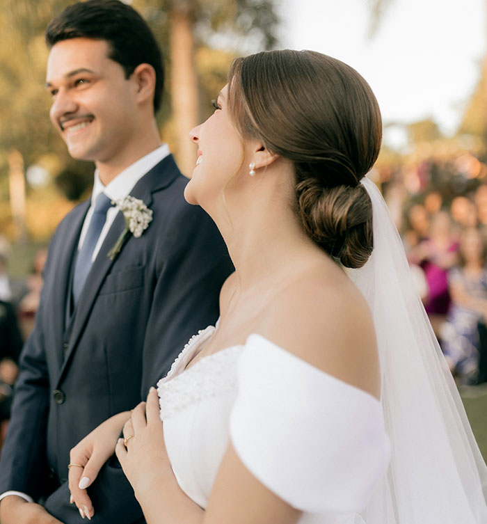 A smiling bride with a veil and groom in a suit at their wedding, representing lasting marriage moments.