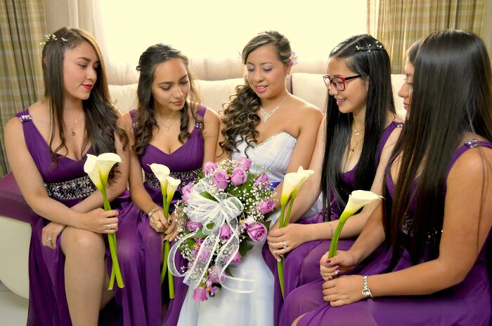 Bride and bridesmaids in purple dresses holding flowers
