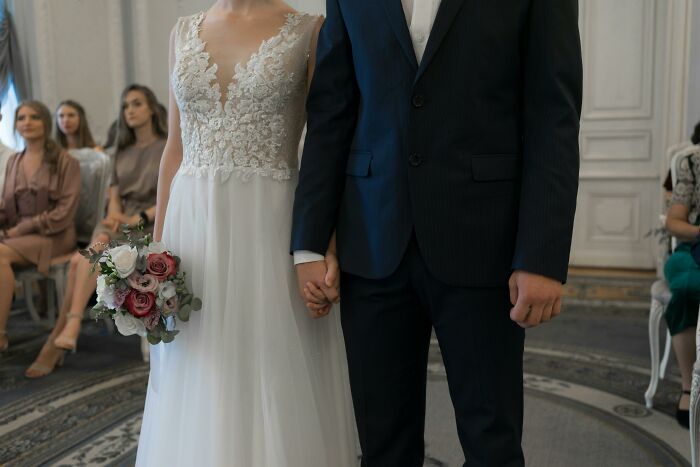 Bride and groom holding hands during wedding ceremony indoors