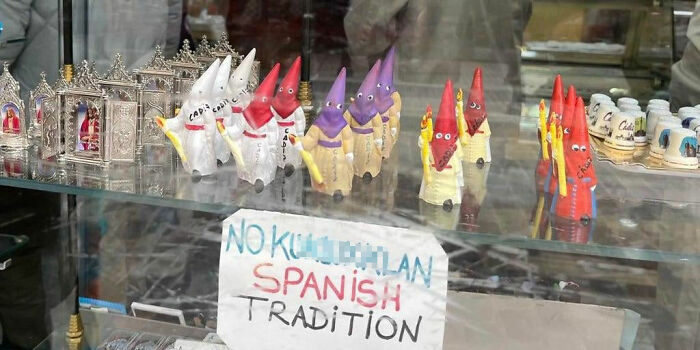 Display of small figurines labeled Spanish tradition in a store window