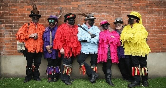 Group dressed in colorful traditional costumes and blackface for cultural event