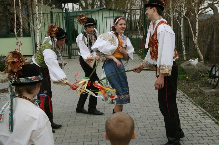 Group in traditional folk costumes performing a cultural dance outdoors
