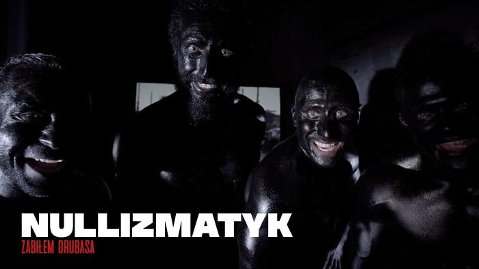 Group of men with dark body paint smiling during a local cultural event