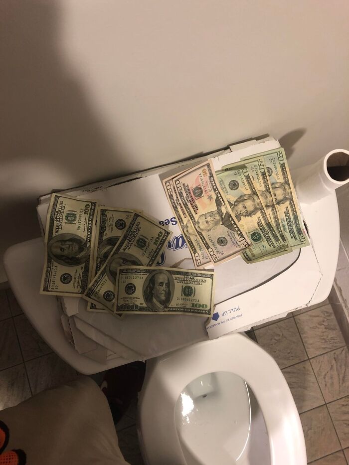 Money bills placed on a toilet paper box symbolizing unexpected acts of kindness payments