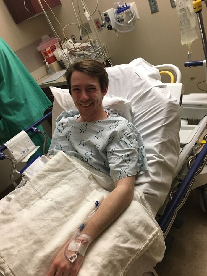 Smiling patient resting in hospital bed receiving medical care and positive support