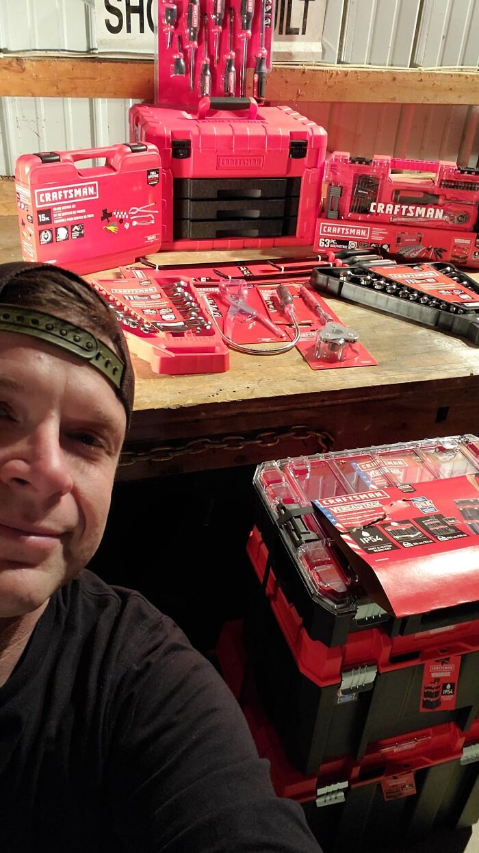 Man smiling with Craftsman toolkits during charitable donation