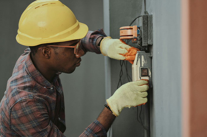 Electrician fixing wiring wearing safety gear revealing career dangers