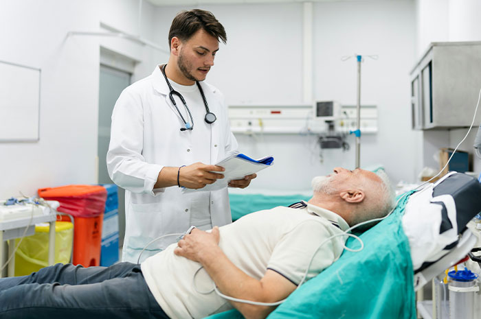 Doctor reviewing notes while attending to elderly patient in hospital