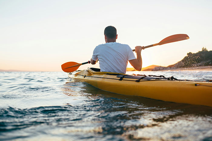Person kayaking on water at sunset demonstrating career-work balance