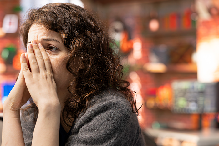 Worried woman covering face upset about pasta and family feud