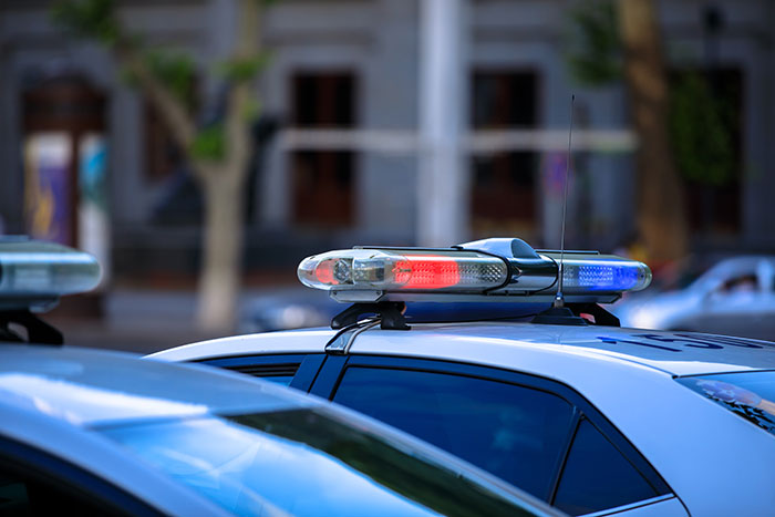 Police car with red and blue lights on top parked on city street Police car with red and blue lights on top parked on city street