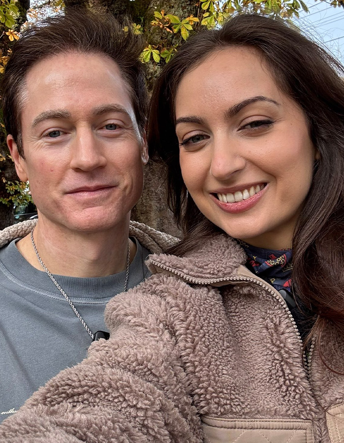 Couple smiling outdoors in cozy clothing for human experiment story