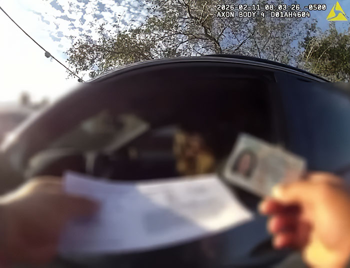 Police officer showing a ticket and ID to woman with no right hand through car window Police officer showing a ticket and ID to woman with no right hand through car window