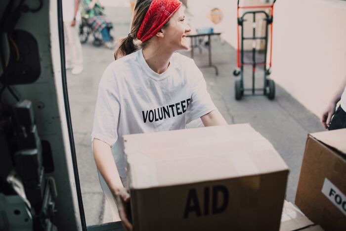 Female volunteer carrying aid boxes at a charity event