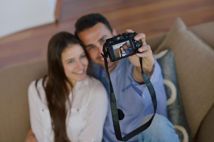 A smiling couple takes a selfie, capturing a happy memory. They look content, far from heartbroken breakups.