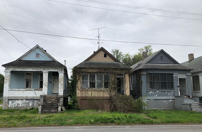 Three neglected and weathered houses with peeling paint in the US