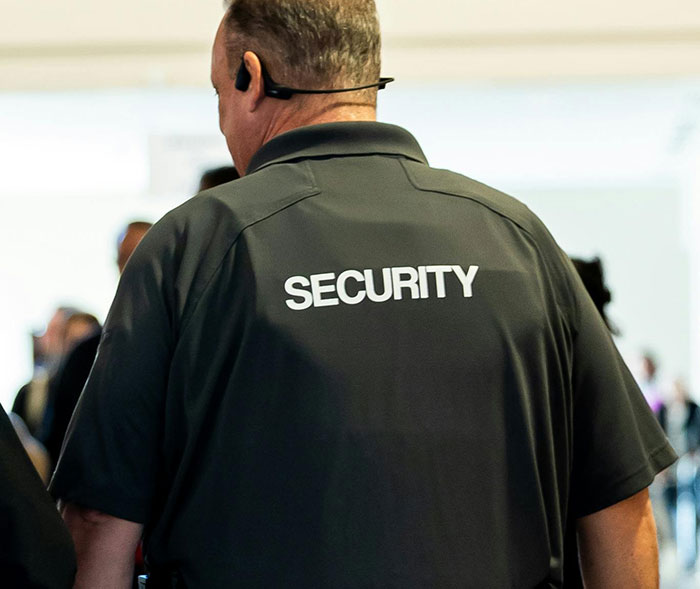 Security guard in black uniform at a crowded event in the US