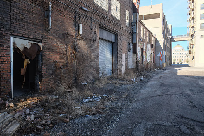 Deserted urban alleyway with broken doors and debris in the US