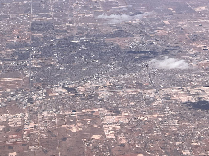 Aerial view of a dry urban area in US, showing sparse landscape and city grid