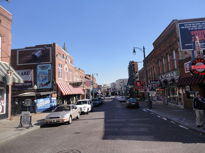 Busy city street with brick buildings, cars, and pedestrians in the US