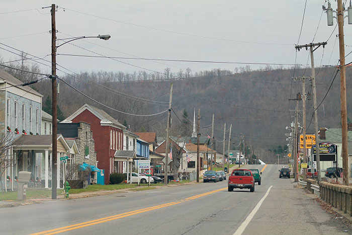 Small town main street with cars and hills in the background in the US