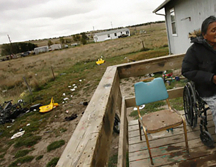 Rundown porch and wheelchair on a cluttered lot in the US rural area
