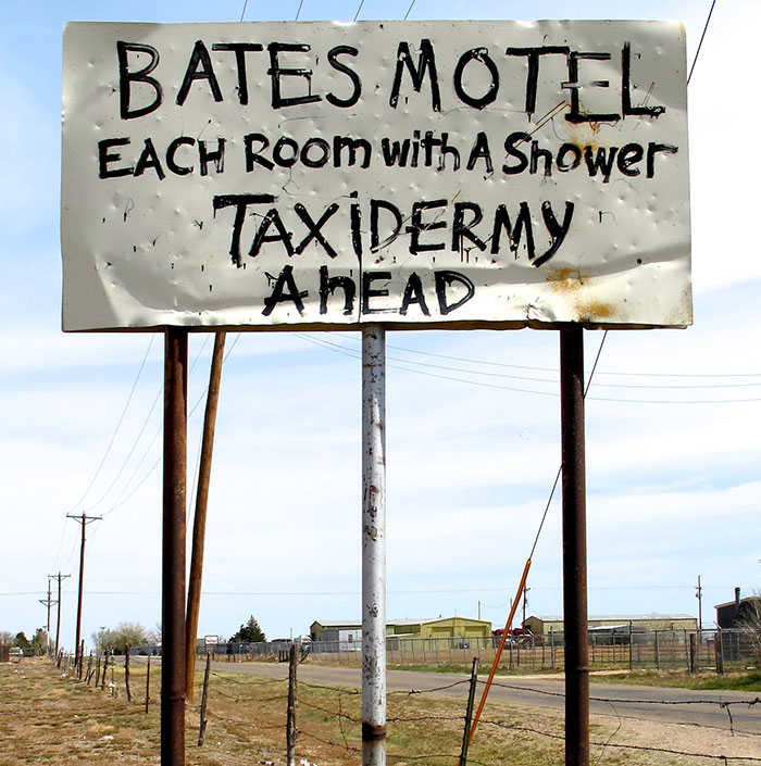 Bates Motel sign warning of taxidermy ahead by roadside in the US
