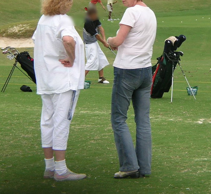 Two women standing on a golf course during practice session