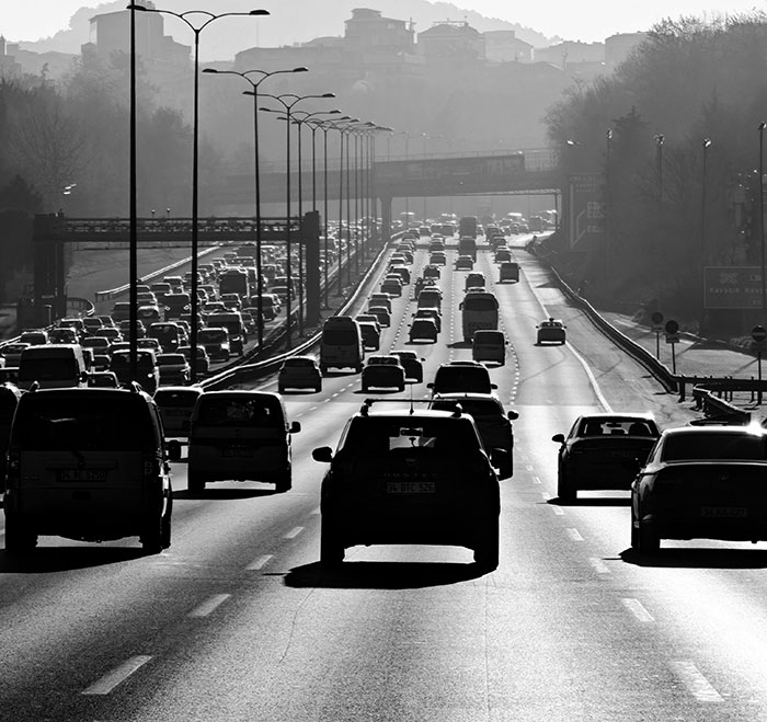 Black and white photo of heavy traffic on a multi-lane highway, proving road rage is no joke for drivers.