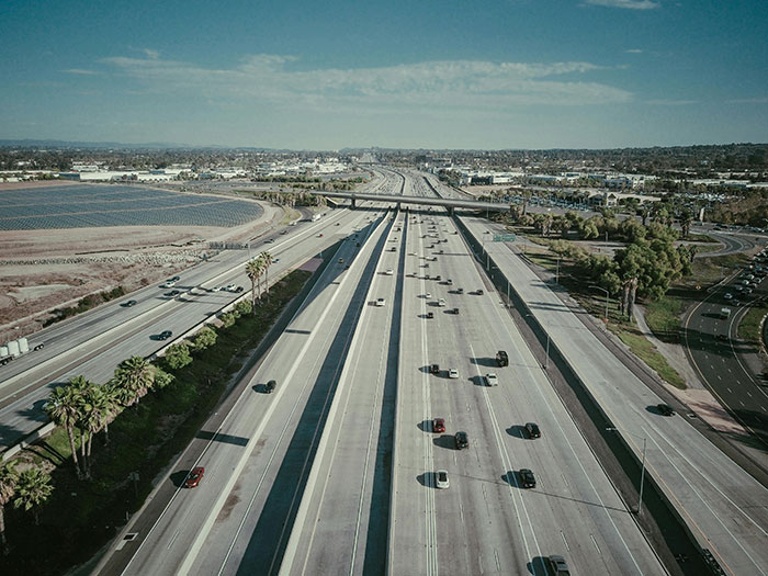 Aerial view of a multi-lane highway with moderate traffic, showing the potential for road rage.