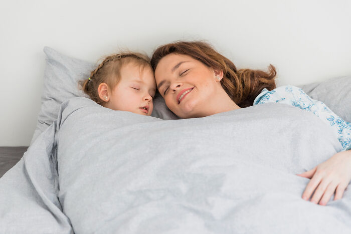 Mother and child sleeping peacefully in bed under gray blanket nightmare stories