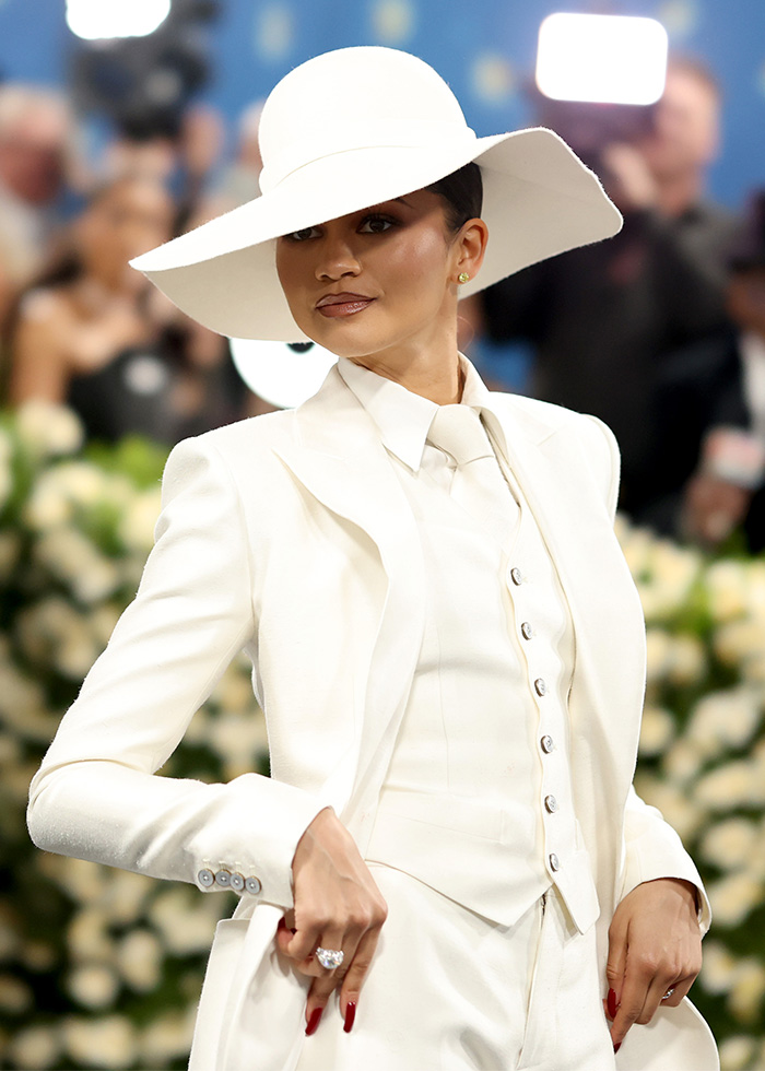 A celebrity in a white suit and wide-brimmed hat, posing. Many celebrities are skipping the Met Gala 2026.