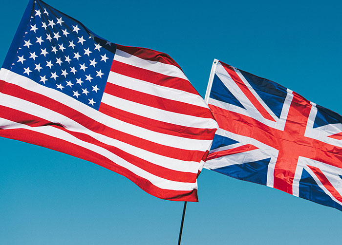 US and UK flags waving against a clear blue sky. This image hints at potential Controversial Beliefs and Arguments.